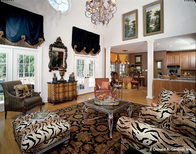 Living room with animal print seats, an ornate coffee table, and a patterned area rug that lays on the hardwood flooring.