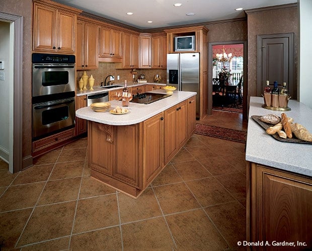 Kitchen with stainless steel appliances, wooden cabinetry, and a cooktop island.