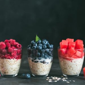 Three servings of overnight oats with various toppings.