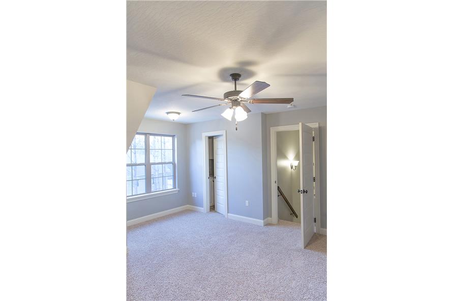 The bonus room has carpet flooring, white-framed windows, and its own bathroom.