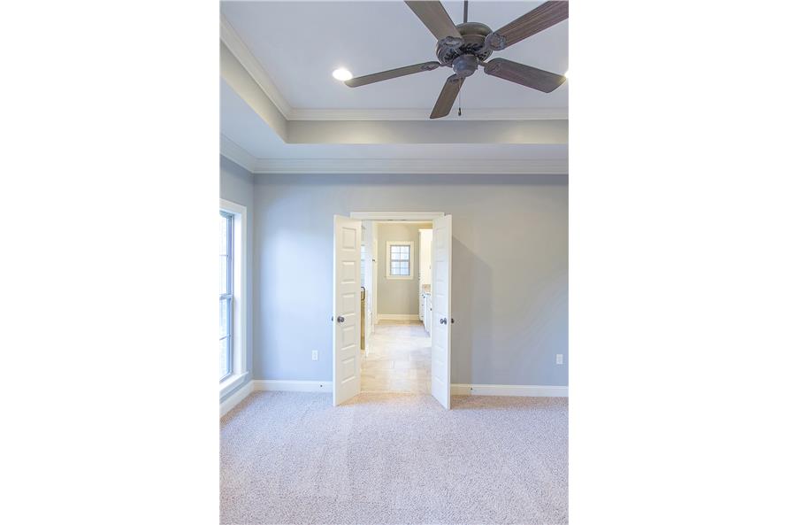 A white double door opens to the primary bathroom.