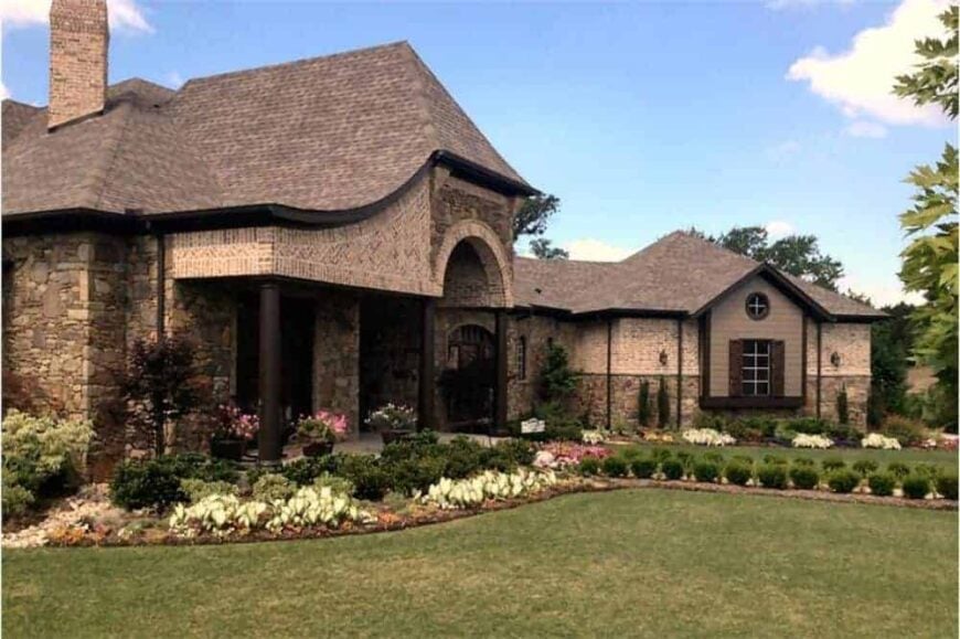 A close-up look at the front porch with decorative archway, dark columns, and stone cladding.