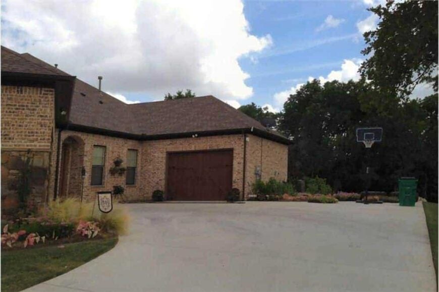 Right exterior view with split garages and a concrete driveway with a basketball ring.