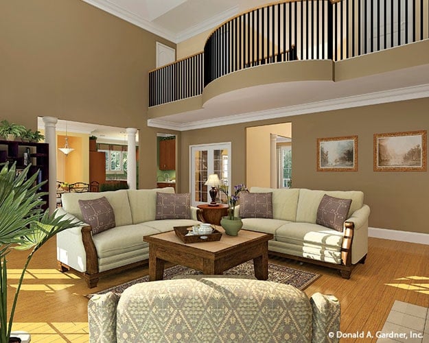 Living room with beige sofas and a wooden coffee table that sits on a printed area rug.