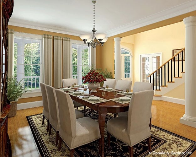 Formal dining room with beige upholstered chairs, an oval dining table, and a glass chandelier.