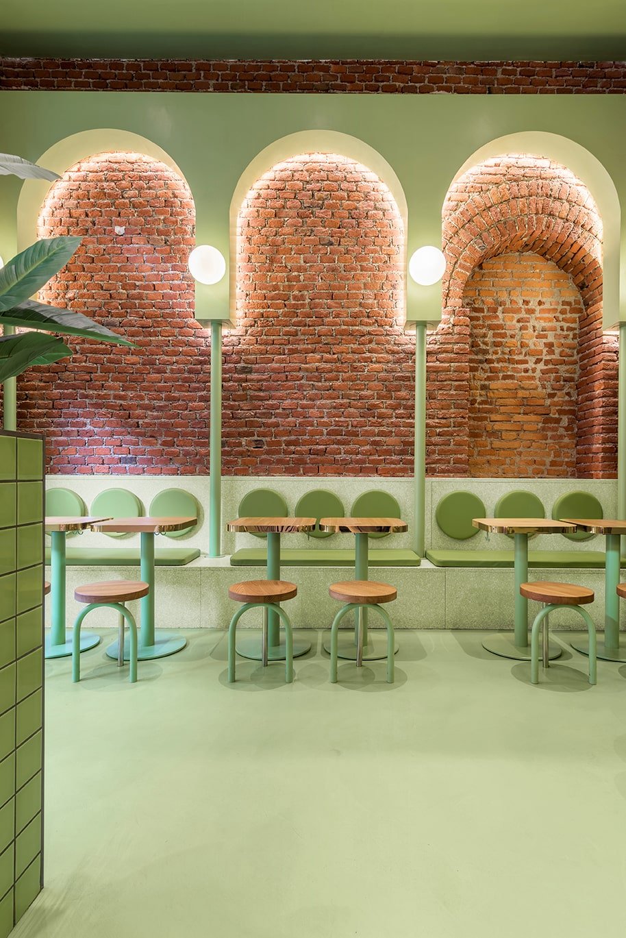 This is another view of the green side of the restaurant with its small wooden tables and small chairs paired with built-in benches on the far side under the red brick wall.