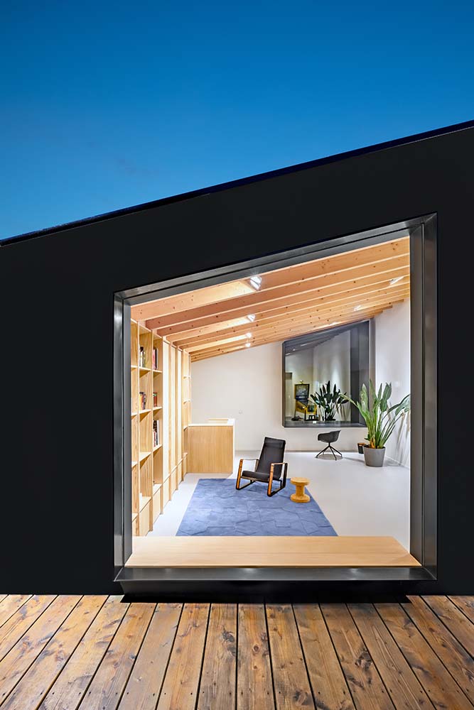 This is a view of the top floor interior from the vantage of the wooden deck balcony.
