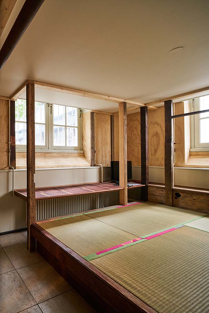 This is a close look at the wooden structures of the open area with natural lights from windows.