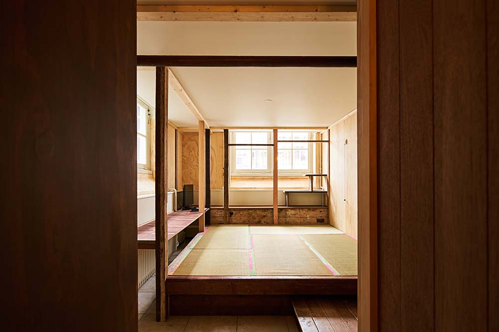 This large open area has a wooden platform in the middle of various wooden beams and pillars.