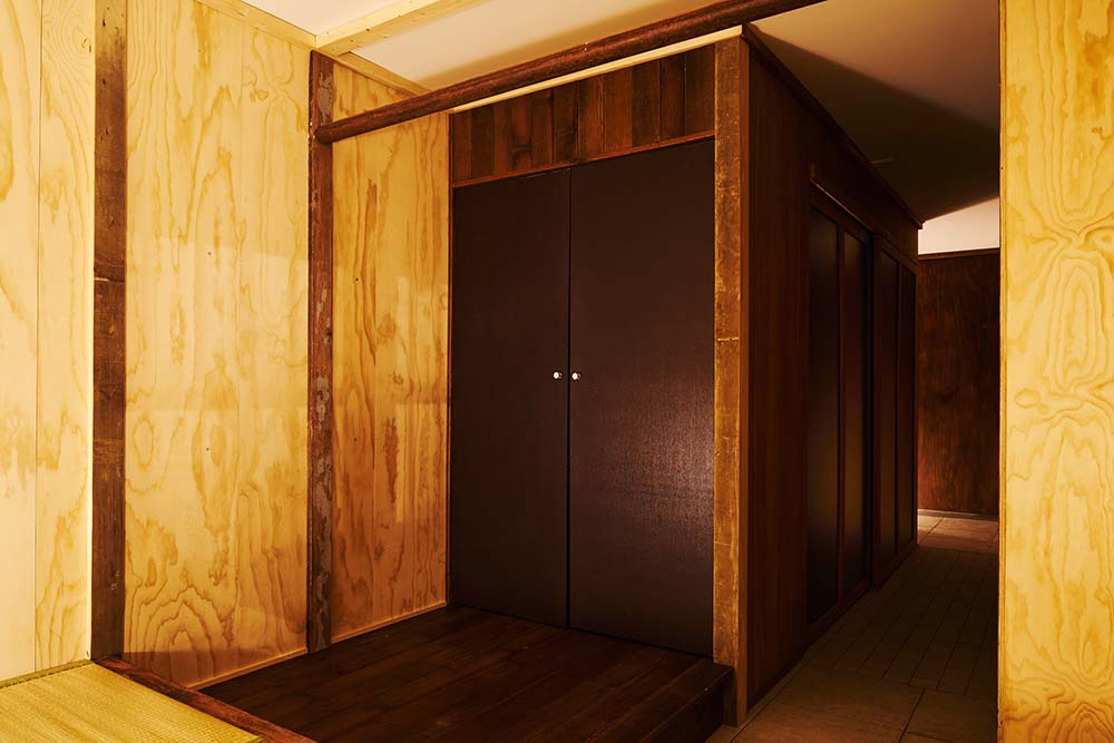 This is a close look at the dark wooden double door of the house with a matching dark wooden deck flooring.