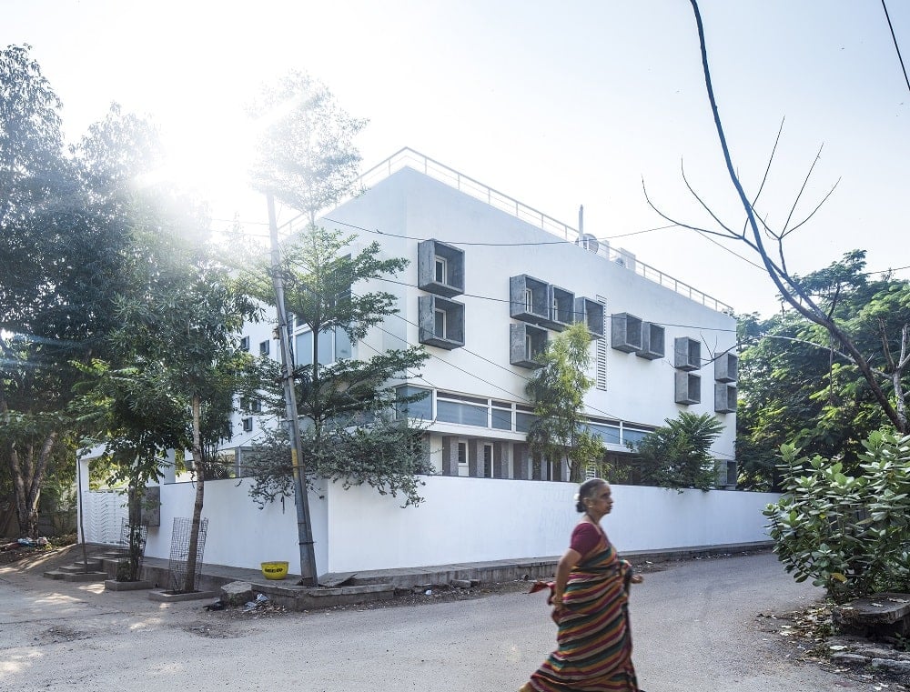 This is a view of the side of the house with white exterior walls and small windows that stand out.