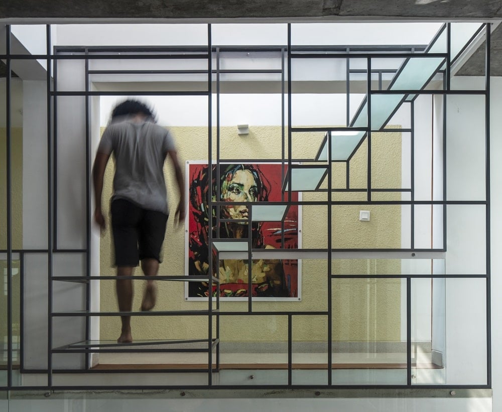 This is a view of the interio showcasing the geometric structure of the wrought iron staircase with frosted glass steps.