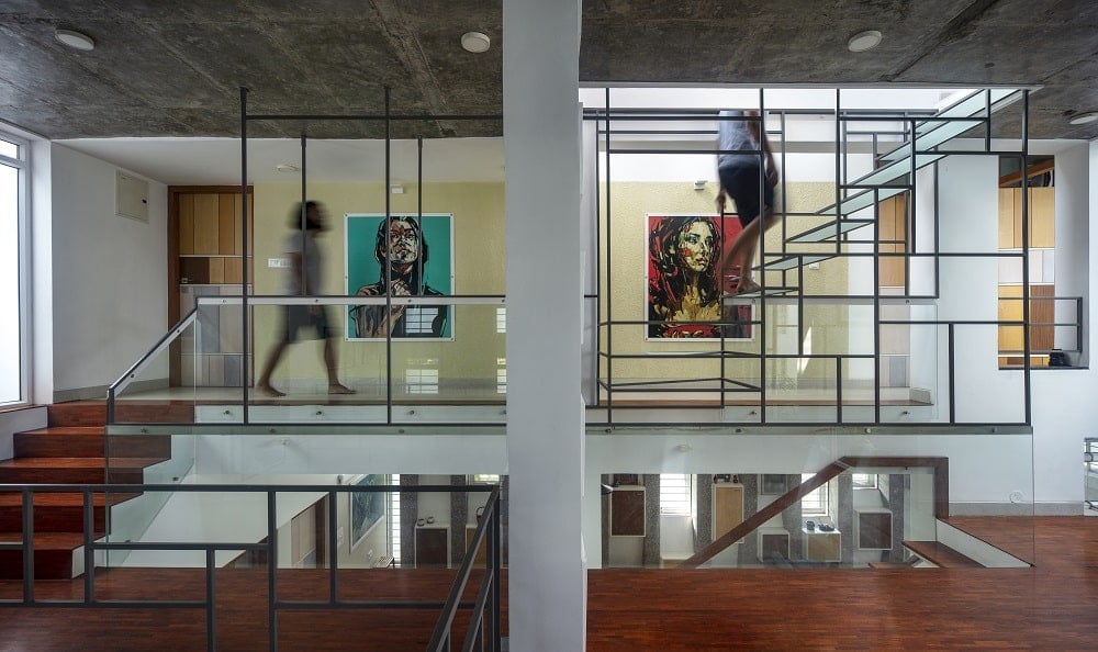 This is an interior view of the upper level with hardwood flooring, lime yellow walls and colorful wall artworks that go well with the wrought-iron structures.