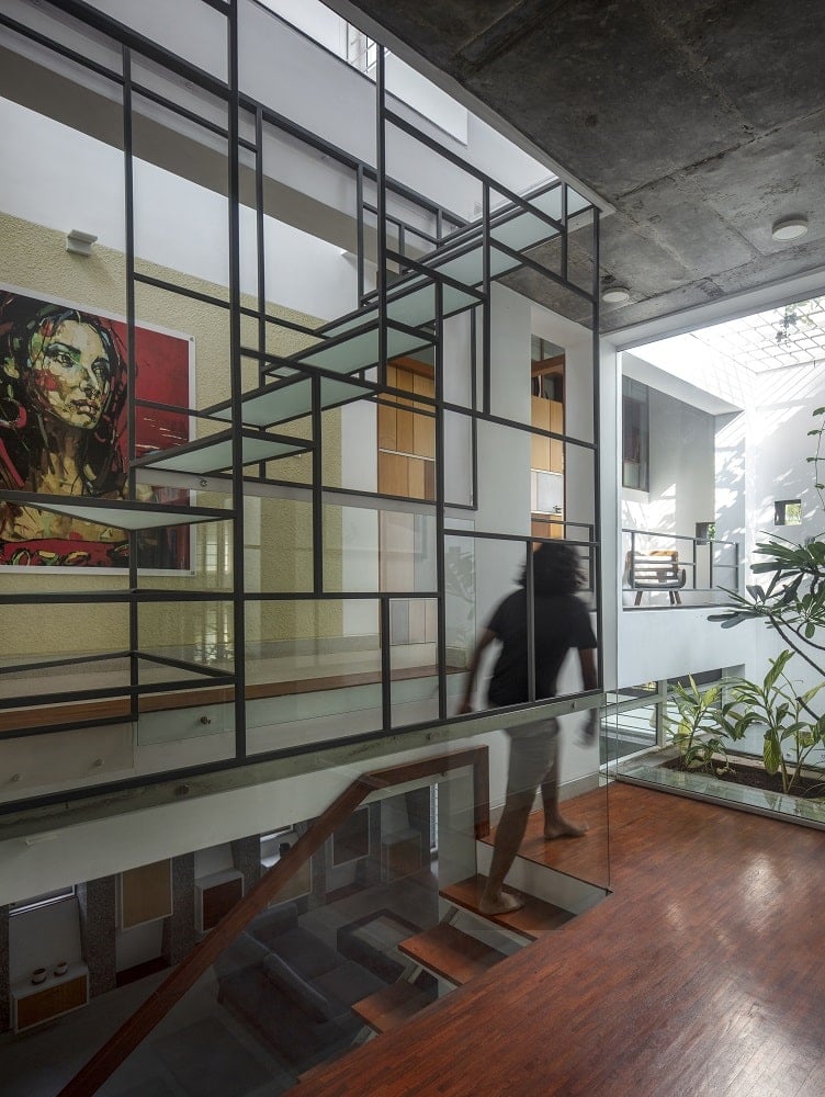 This is a close look at the landing that has a hardwood flooring and a glass wall that looks over the indoor garden.