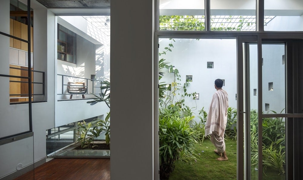 The house has a glass door that leads out into the indoor garden of the house that serves as a terrarium with direct sunlight from above.