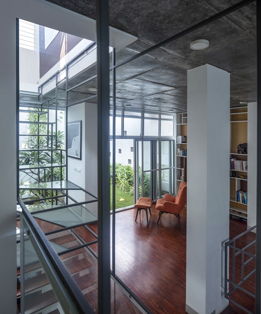 On the side of the indoor garden is a reading area with a lounge chair and built-in bookshelves on the side.
