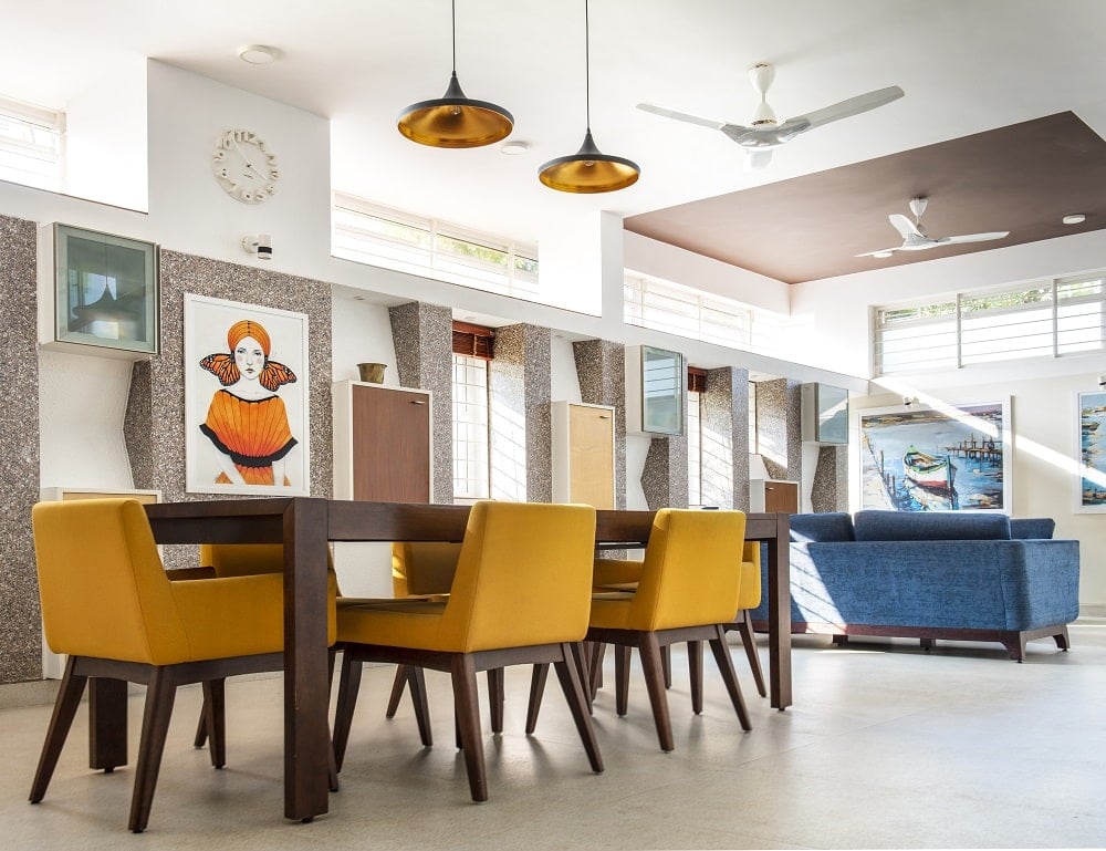 This is the close look at the dining area with a large rectangular dining table surrounded by beige cushioned chairs.