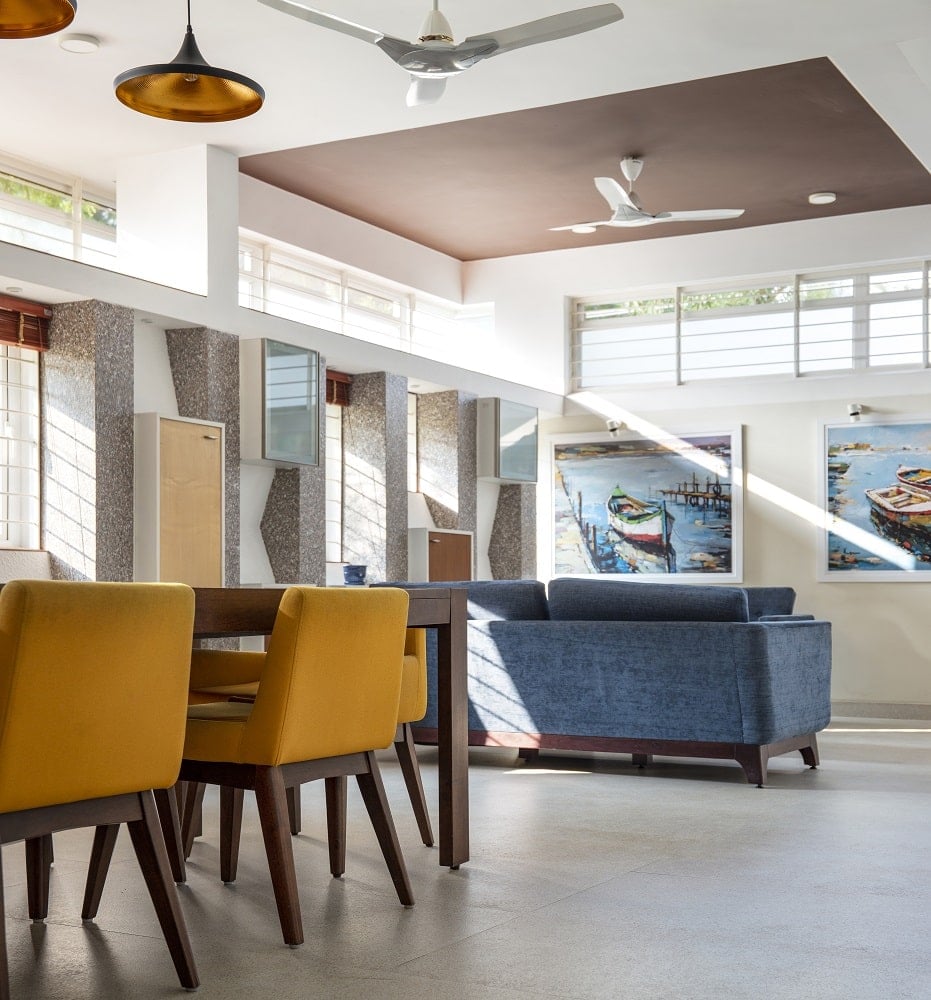 The living room area also has a dark gray sofa topped with a dark brown tray ceiling contrasted by the bright beige walls.