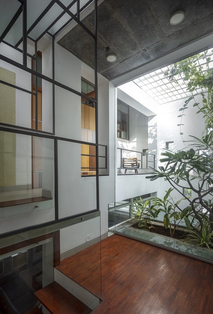 This is the landing of the staircase that has a glass wall that looks out to the indoor garden of the house and lets in natural light.