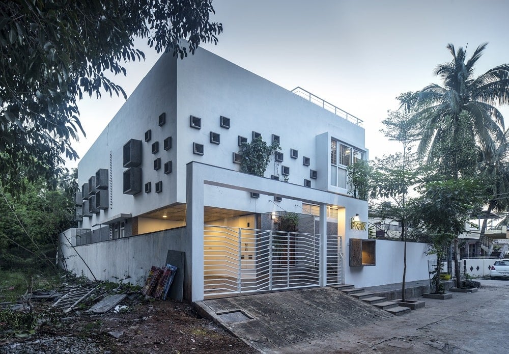 This view of the front of the house shows an inclined concrete driveway leading to the car port of the house.