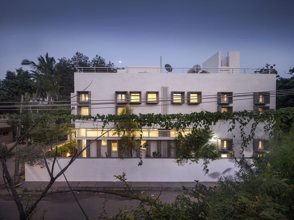 This nighttime view of the side of the house showcases the warm glow of the small windows giving the house a unique look.