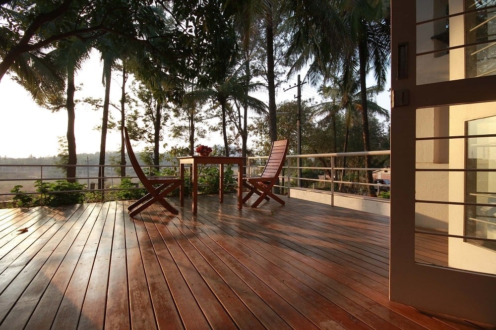 This wooden deck terrace is complemented by the tall trees in the background that also give shade to the area.