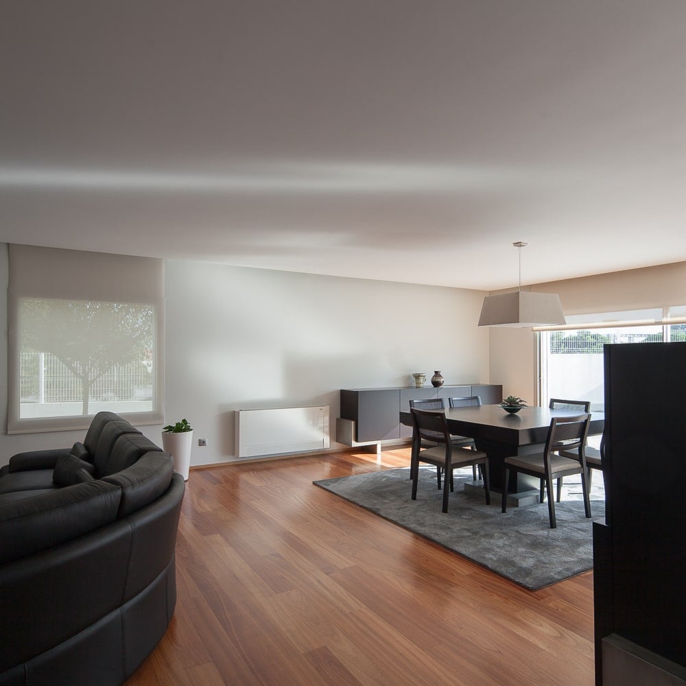 This is a view of the great room showcasing the large black leather sectional sofa that is only a few steps away from the dining area.