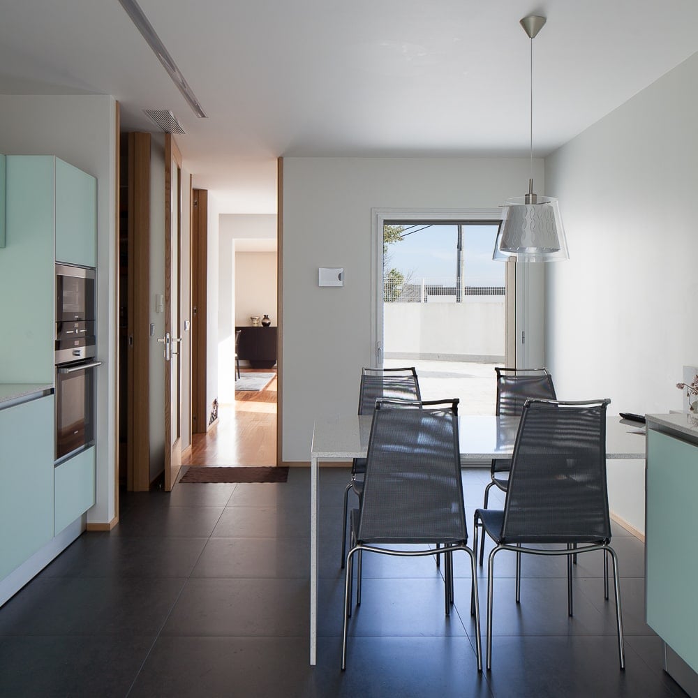 This is a close look at the modern eat-in kitchen with a modern dining set and pastel blue cabinetry that makes the appliances stand out.