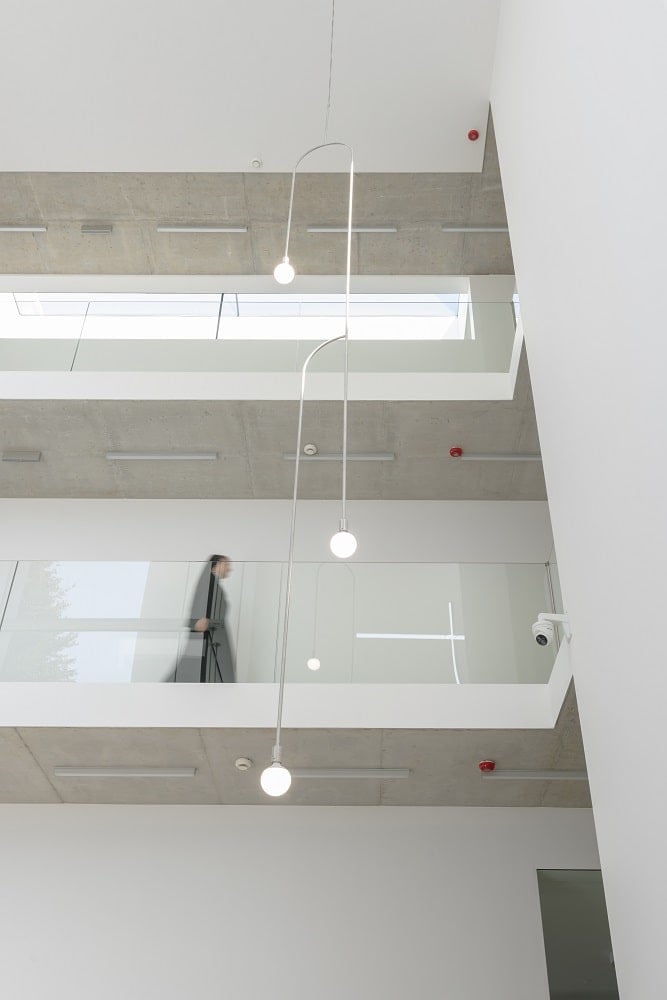 This is a look at the interior atrium of the monastery with indoor balconies that has glass railings.