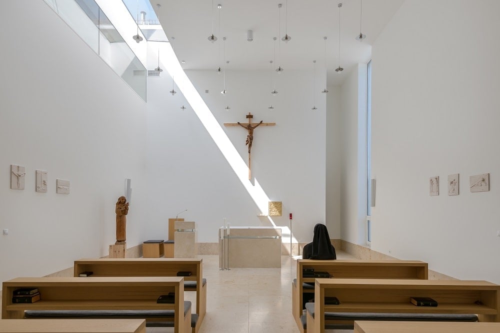 This is a close look at the chapel of the monastery with plain beige walls, tall ceiling and beige flooring tiles.