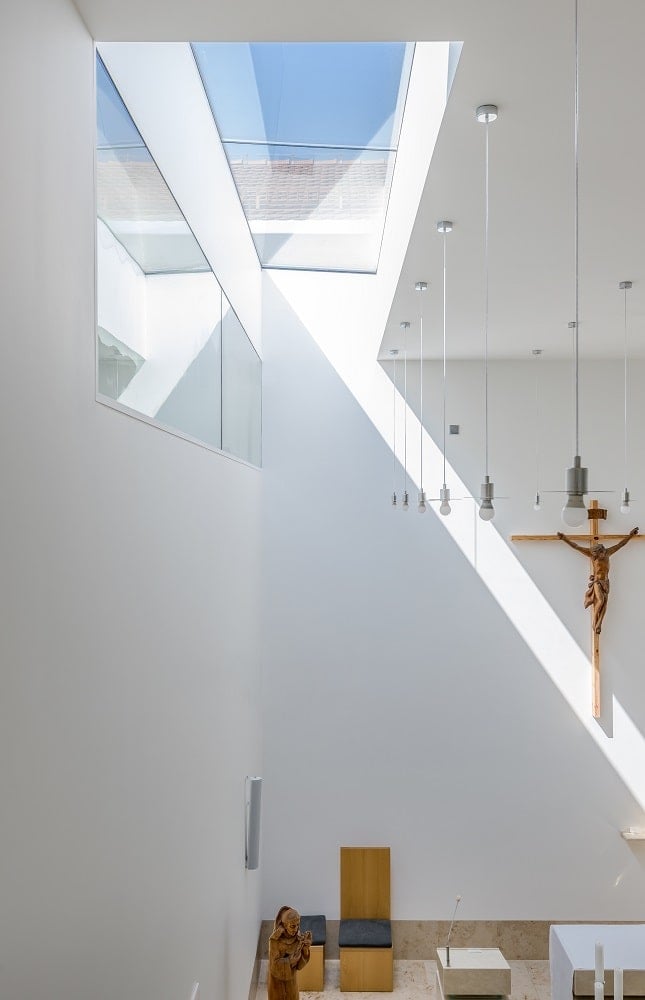 This is a closer look at the far wall of the chapel that has a crucifix mounted on the wall. You can also see here the skylights on the side that bring in natural light.