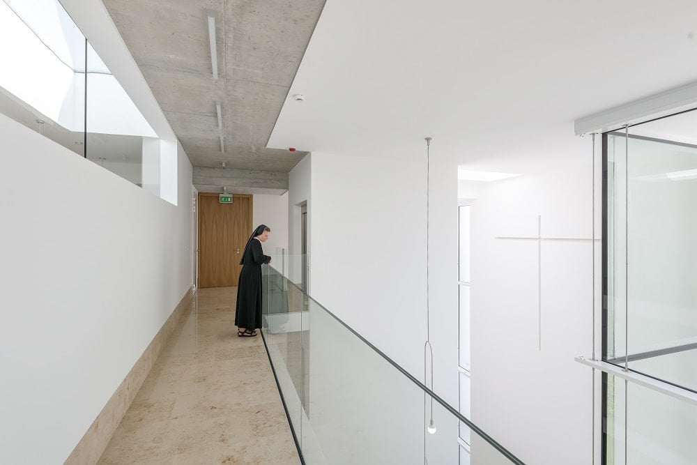 This is a look at the top indoor balcony with its glass railings and beige walkway.