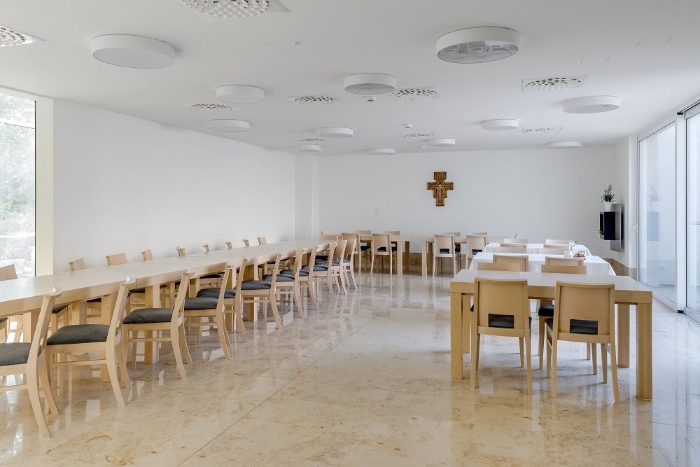 This is a close look at the large dining room with multiple large table and chairs to accommodate a large number.