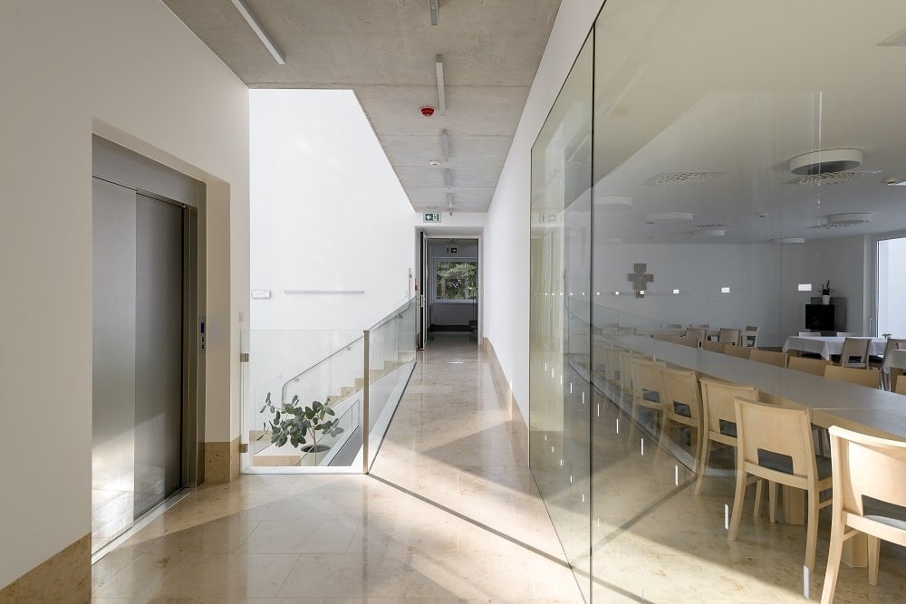 This is a close look at the hallway, just outside the glass wall of the dining room with an elevator access on the side.