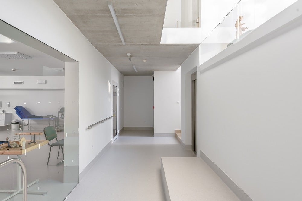 This is the hallway just outside the glass wall of the infirmary with an abundance of natural lighting coming in from above.