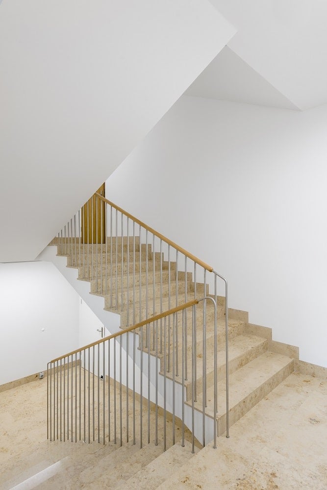 This is the staircase with beige steps and thin wrought-iron railings.