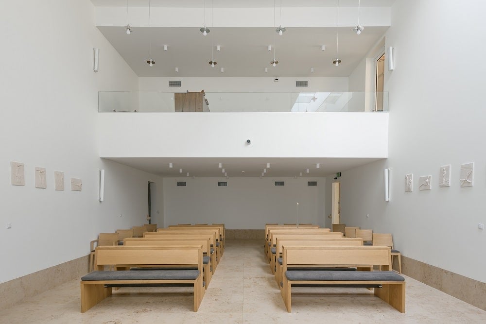 This is the chapel across from the altar with multiple wooden pews and even an upper loft for additional space.