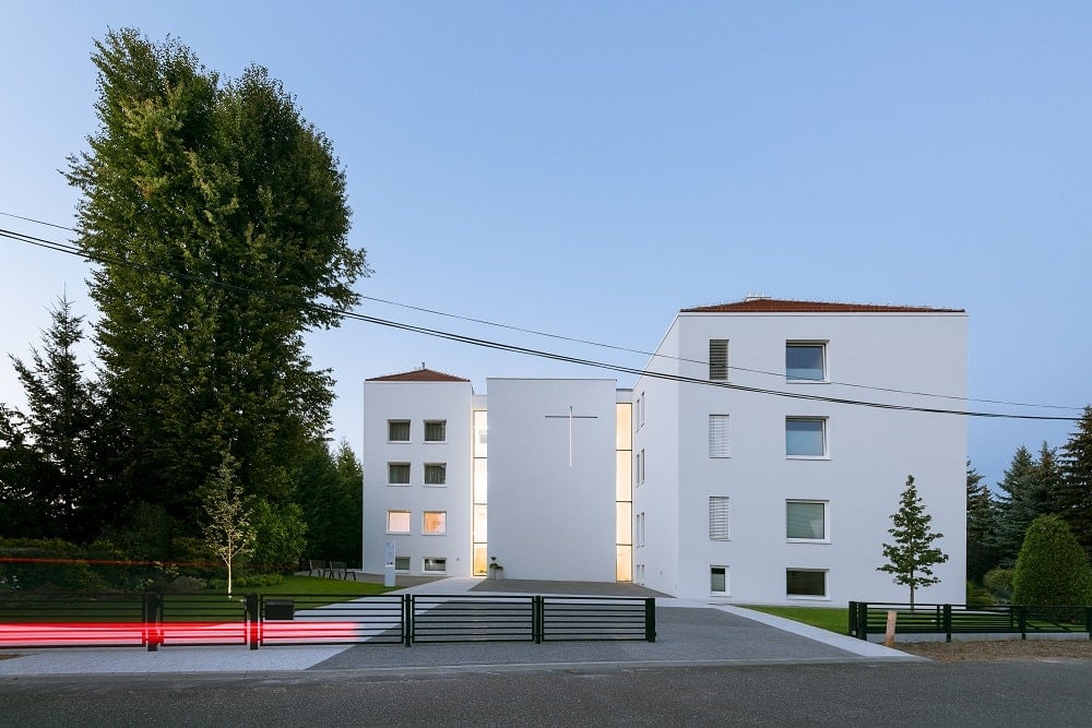 This is a look at the monastery from the driveway with its bright exterior walls with a modern aesthetic.