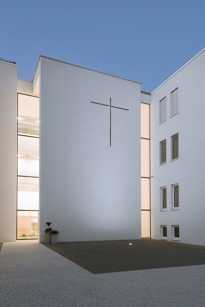 The windows of the monastery glow warmly with yellow light coming from the interior lights.