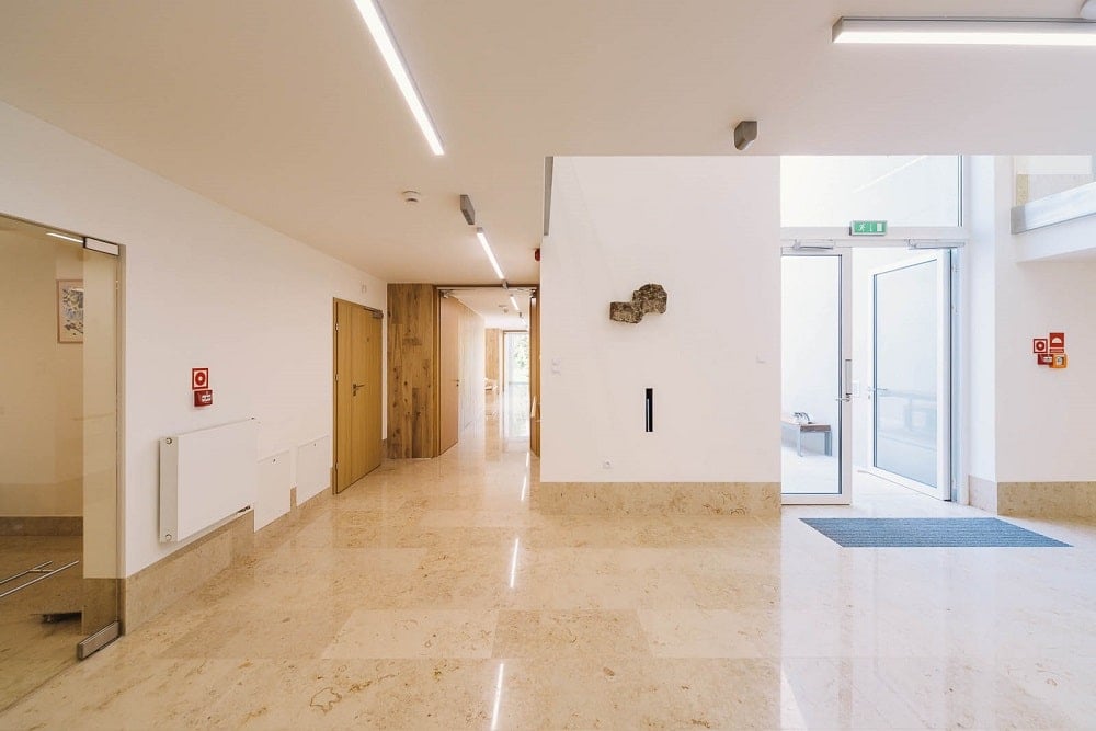 The interior of the senior house has beige marble floors and wide hallways.