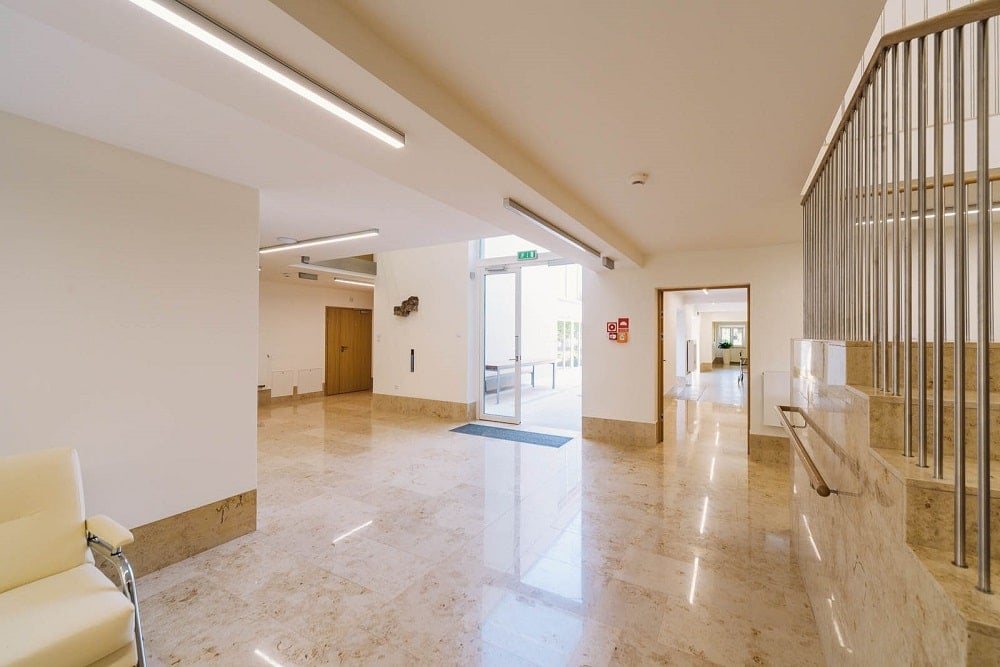 The interior of the senior house has beige marble floors and wide hallways brightened by the natural lights.