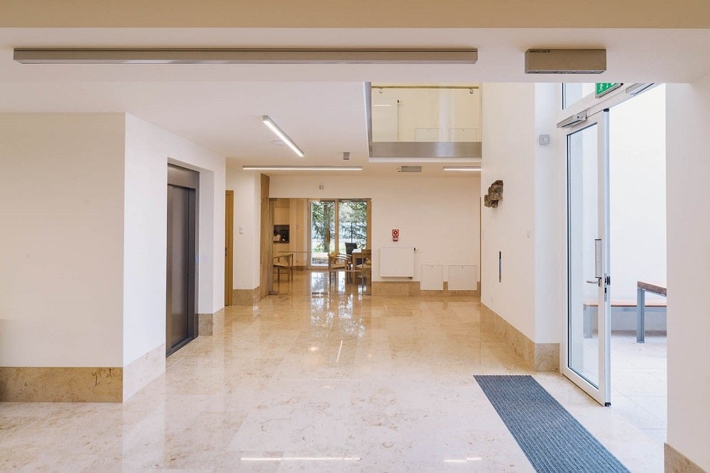 The interior of the senior house has beige marble floors and wide hallways brightened by the natural lights.