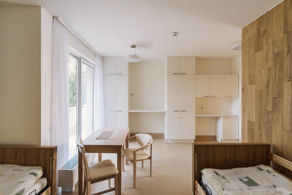 This bedroom has a set of built-in cabinets and shelves on the far side opposite the bed.