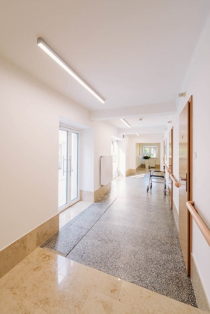 The upper floor of the senior house has wide hallways with beige walls and ceiling.