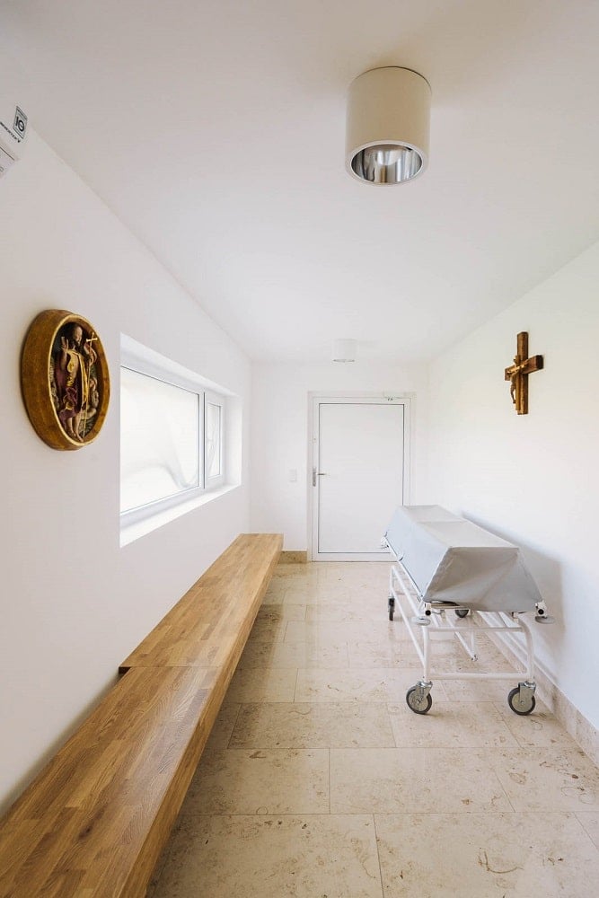 This is a room brightly lit by the natural lights coming in from the large window above the built-in wooden bench.