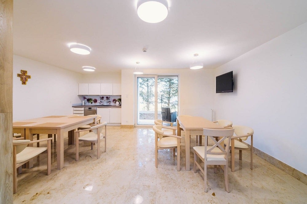 Across from the kitchenette is a pair of dining sets that has wooden tables and chairs.