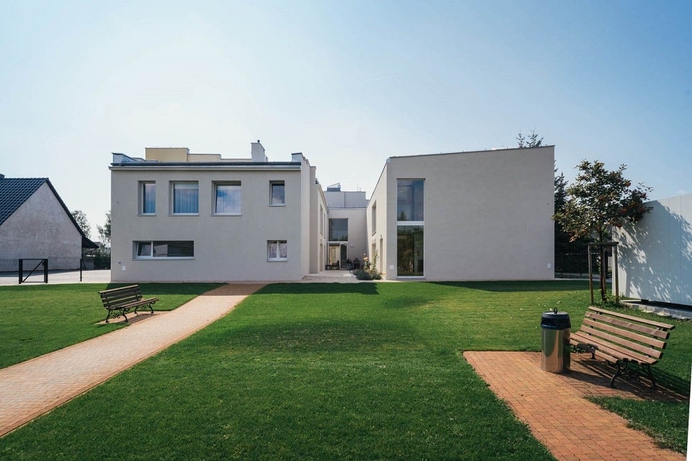 This is a view of the large grass lawn with walkways and a view of the senior house exteriors.
