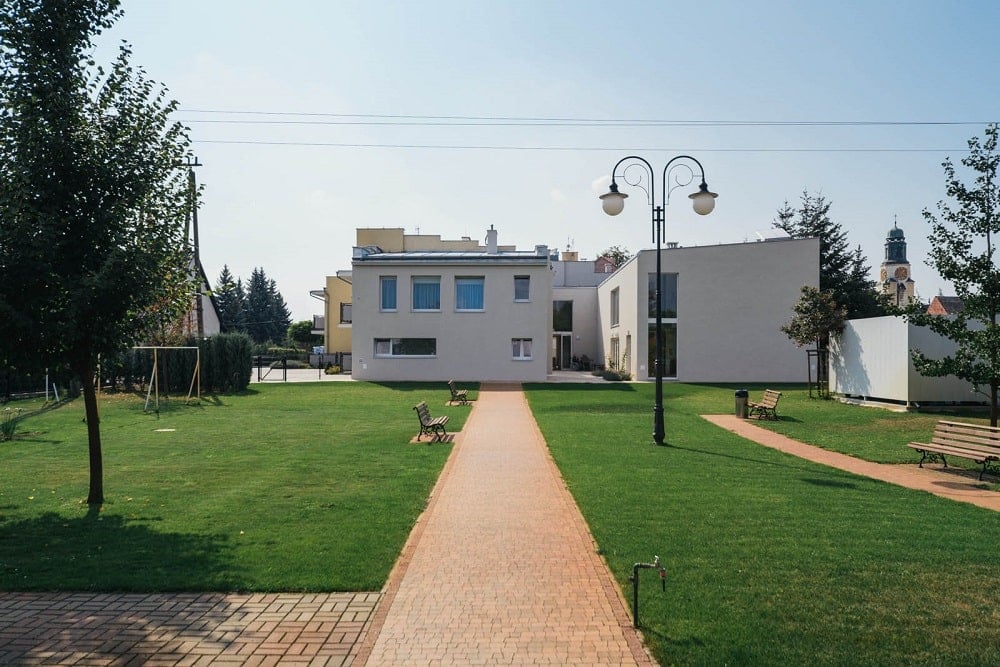 This is a view of the large grass lawn with walkways and a view of the senior house exteriors.