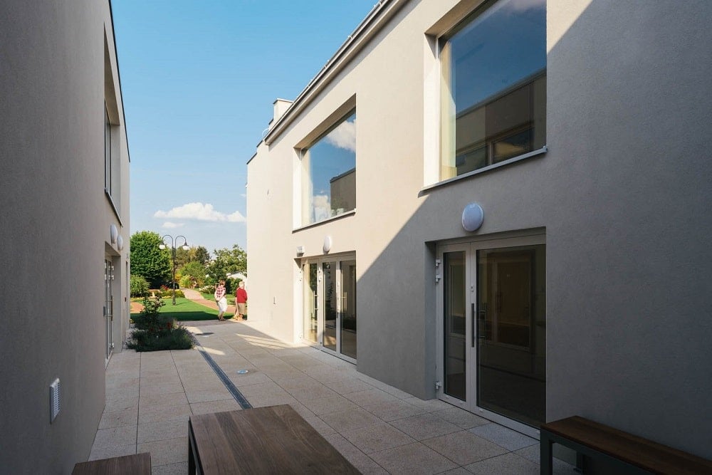 This is a close look at the courtyard of the senior house with an outdoor dining area and miniature garden.