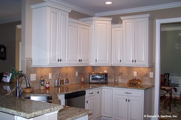 Kitchen with white cabinetry, stainless steel appliances, granite countertops, and a double-bowl sink.